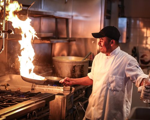 man in white chef uniform cooking