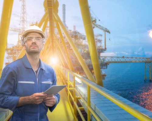 Caucasian man engineer staff worker with tablet in hand and offshore rig background concept.